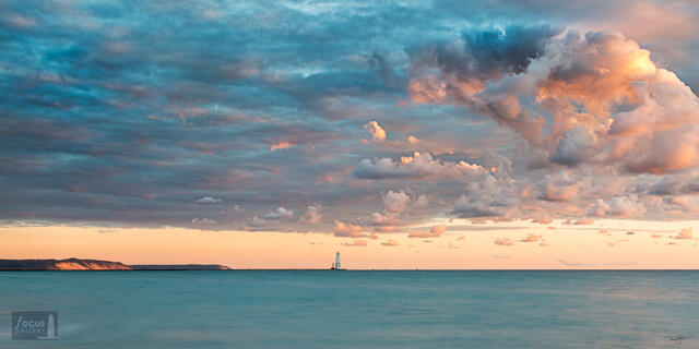 Frankfort Lighthouse and Lake Michigan and colorful clouds.