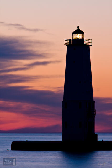 Colorful sunset and the silhouette of the Frankfort Lighthouse.