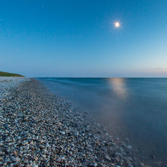 Moon shining over rocky shoreline of Lake Michigan at Point Betsie.