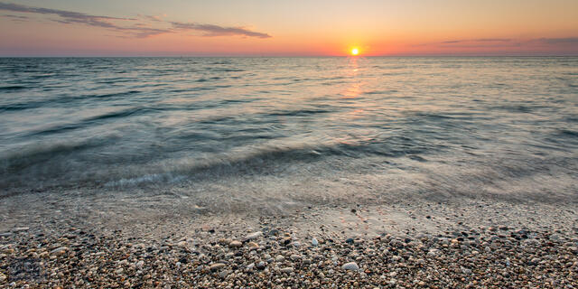 Sunset over Lake Michigan and rocky shoreline at Point Betsie.