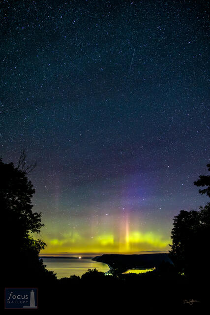 Aurora borealis and sky full of stars over Sleeping Bear Dune.