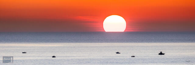 Sunset on Lake Michigan with fishing boats.