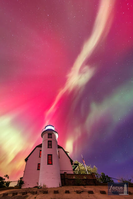Red aurora borealis overhead at Point Betsie Lighthouse, Frankfort Michigan, night