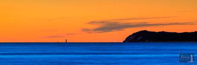 Lake Michigan at dusk, with the Frankfort North Breakwater Light on the distant horizon.