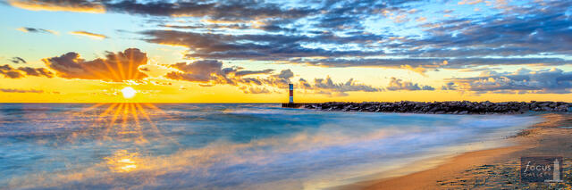 Sunset over Lake Michigan at Arcadia, Michigan, with a breakwater and channel light at right.