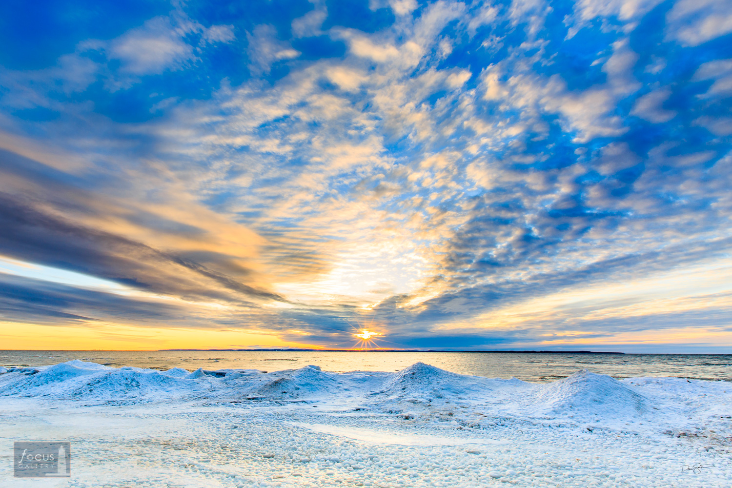 Winter sunset over icy shoreline of Lake Michigan.