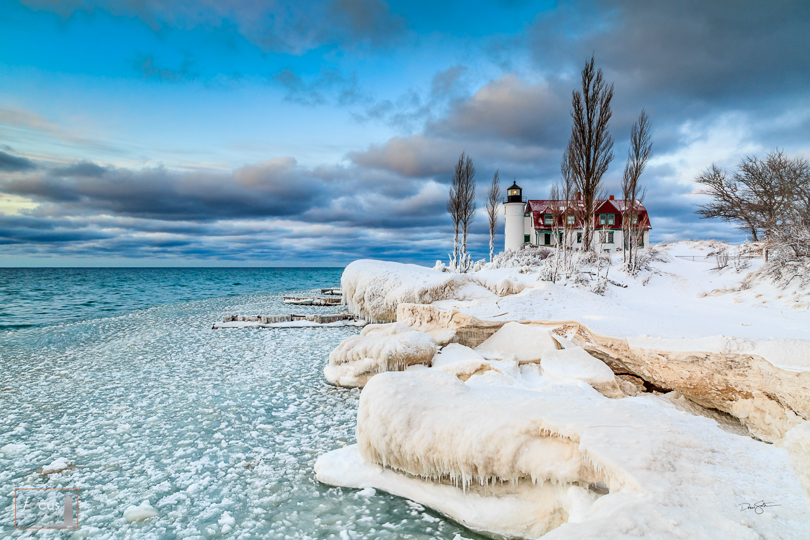 Snowy winter shoreline at Point Betsie with ice on Lake Michigan.