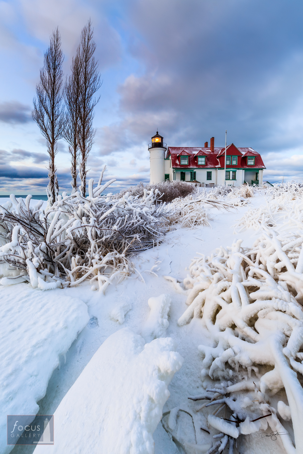 Winter   snow and ice coat the bushes and beach at Point Betsie Lighthouse.