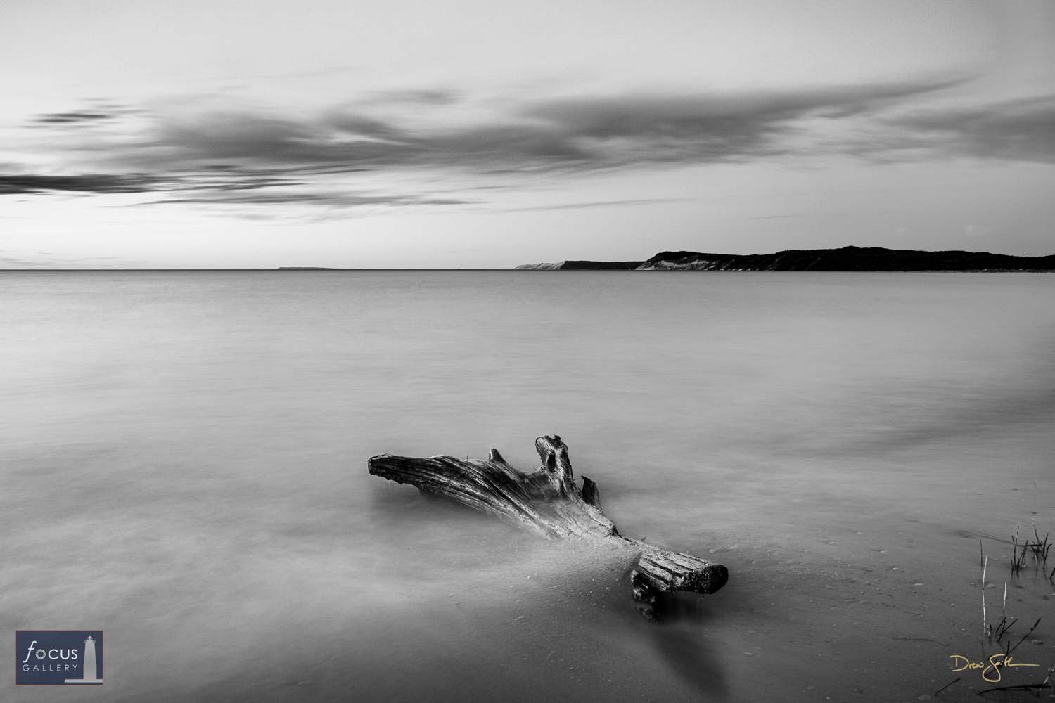 Photo © Drew Smith A driftwood log lays partially buried in the sand along Lake Michigan at Platte River Point. I used a long...